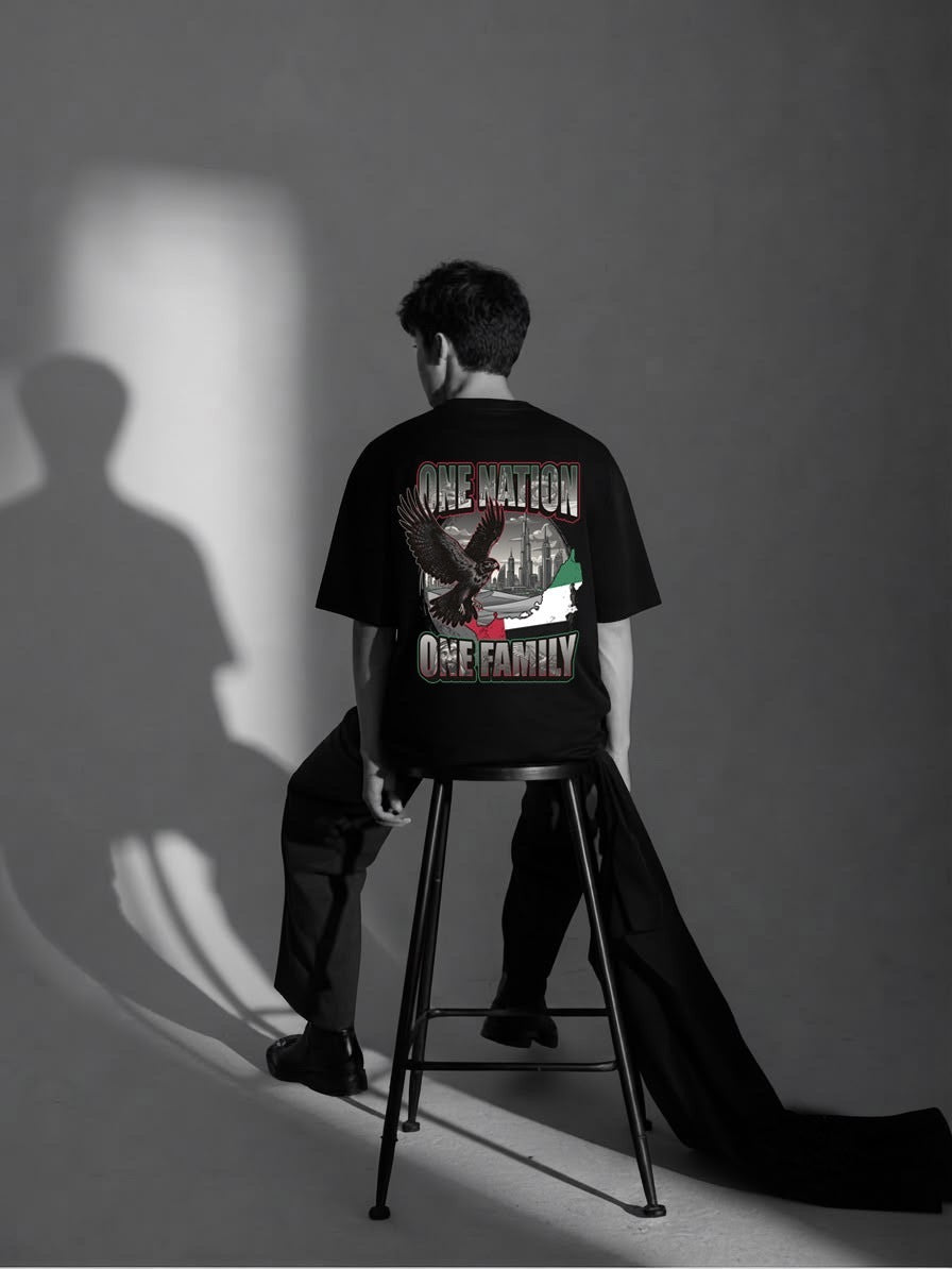 Man showing the One Nation One Family falcon and UAE back print on the black RB Wovens oversized tee