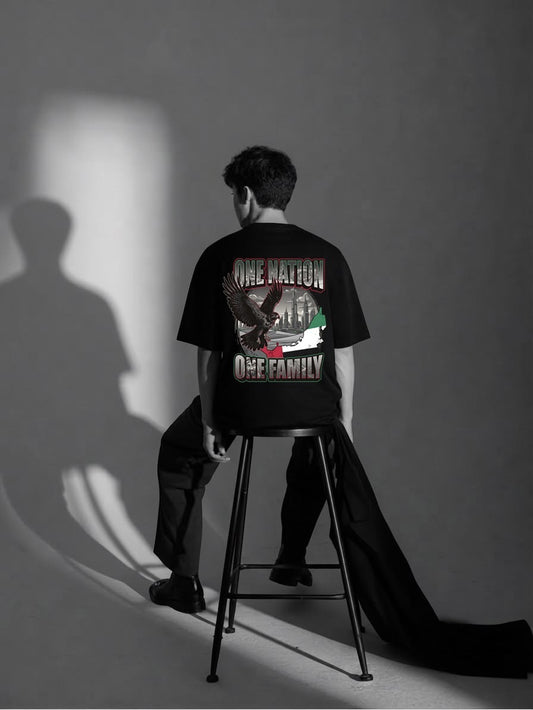 Man showing the One Nation One Family falcon and UAE back print on the black RB Wovens oversized tee